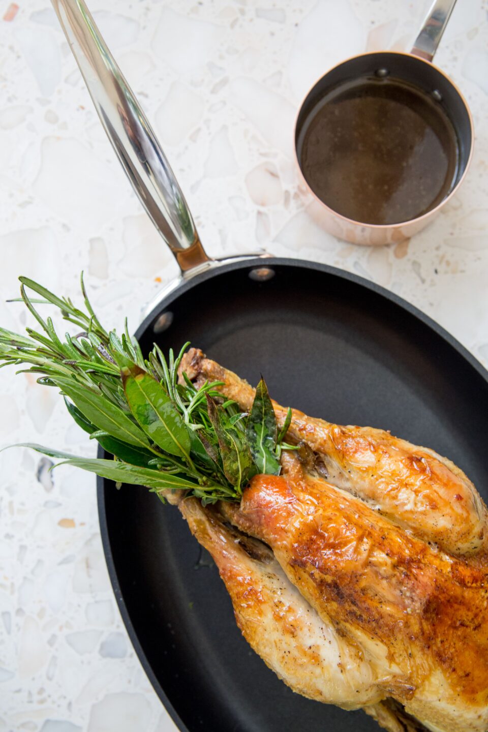 Photo d'un poulet rôti accompagné de son jus réduit